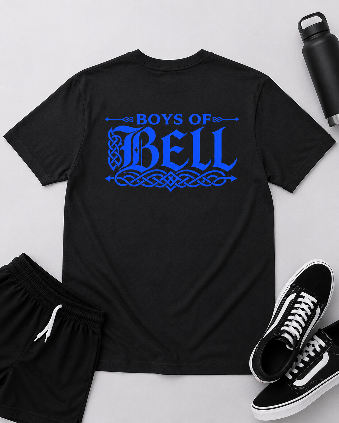 A black short-sleeve t-shirt with a blue 'BOYS OF BELL' graphic printed on the back, styled in a flat lay with black shorts, black sneakers, and a black water bottle on a light gray background.