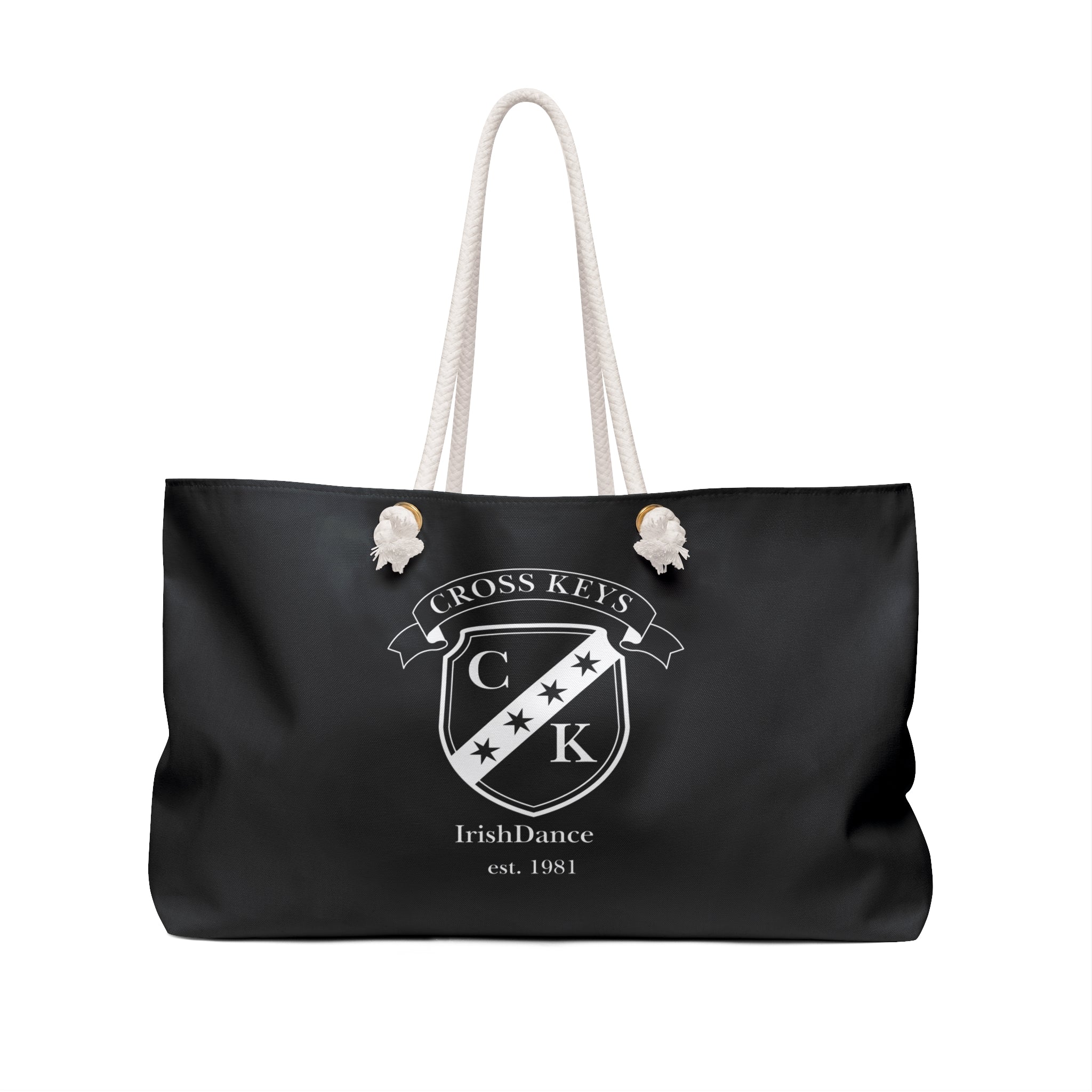 A black tote bag with cream rope handles, featuring a white printed crest and the text 'CROSS KEYS', 'IrishDance', and 'est. 1981' on the front.