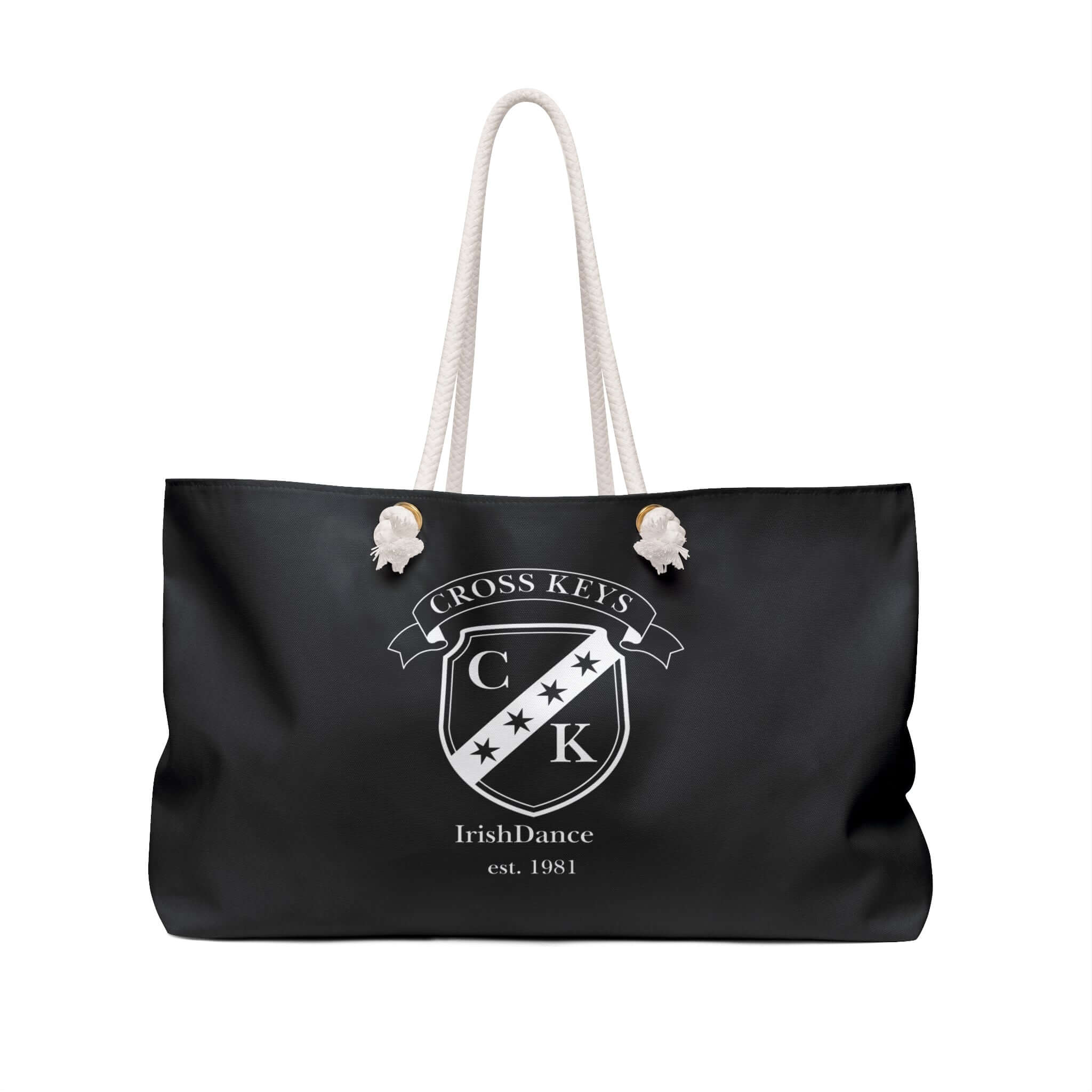 A black tote bag with cream rope handles, featuring a white printed crest and the text 'CROSS KEYS', 'IrishDance', and 'est. 1981' on the front.