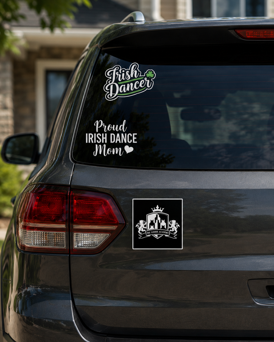A black square decal with a white crest and crown is shown applied to the rear left side of a dark gray SUV. The vehicle is parked outdoors in front of a house, with other white decals on the back window visible.
