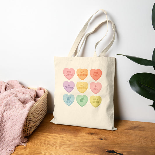 Gaelic conversation hearts tote bag on pink background

Irish love phrases canvas tote bag flat lay

Natural canvas tote with Gaelic Valentine hearts

Irish language tote bag with pastel hearts