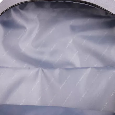 Close-up of the interior lining of a light gray or silver backpack, showing a smooth, slightly glossy fabric with a repeating faint 'BAGGU' watermark pattern and a black zipper along the top edge.