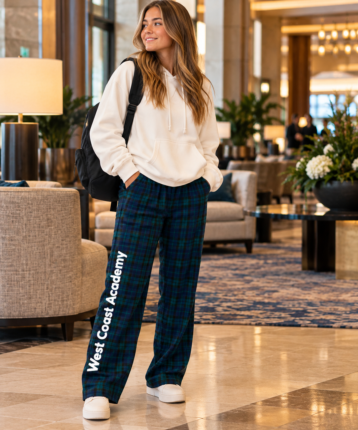 Dancer wearing West Coast Academy tartan flannel pants and a white hoodie, cozy Irish dance gear for Oireachtas travel