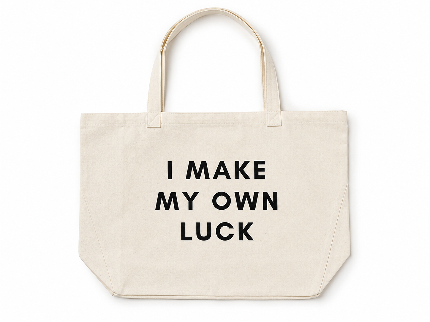 A natural canvas tote bag with black printed text reading 'I MAKE MY OWN LUCK' on the front, set against a plain white background.